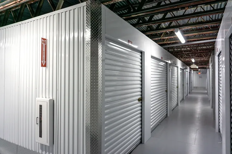 Climate-controlled indoor storage hallway with secure roll-up units